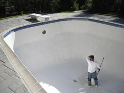 photo of man refinishing a pool