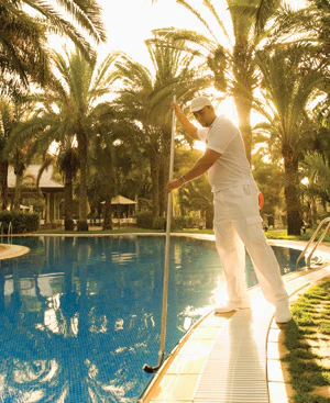 photo of a man cleaning an outdoor pool