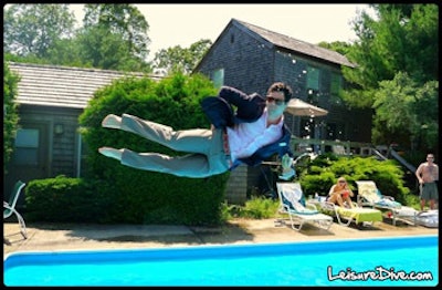 photo of guy with a martini diving sideways into pool