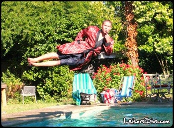 photo of guy with a pipe diving sideways into pool