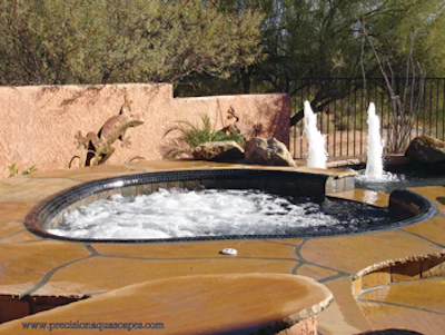Image of outdoor hot tub with water fountains in background