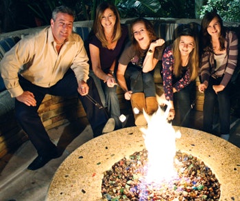 The author’s family enjoys the warmth of their fire pit in comfort and safety. (Courtesy: The Green Scene Landscaping and Pools)