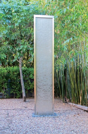 This water feature is known as a water veil, a structure that sends a very subtle flow off water caressing a screen.