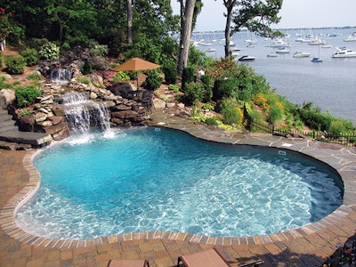 This elegant pool and waterfall combination came to us from LOOP-LOC and was designed and built by True Blue Swimming Pools of Dix Hills, N.Y. Located in a spectacular ocean-front setting on Long Island, this project stands as an example of a vinyl-lined pool installed in a space where most people would expect to find a custom gunite/shotcrete pool. It's an inviting oasis where family and friends can enjoy the aquatic view, well appointed landscape and the sound of moving water courtesy of the elaborate rock structure.