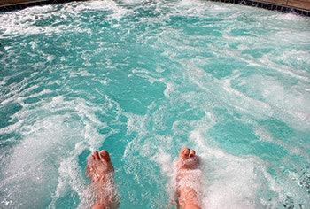 photo of someone's feet splashing in a pool
