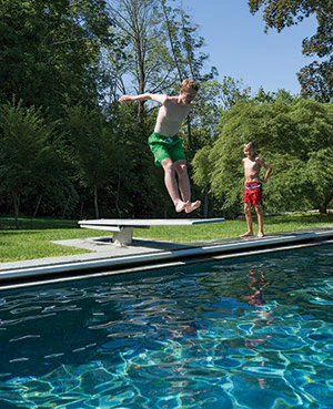 photo of a boy jumping off of a diving board