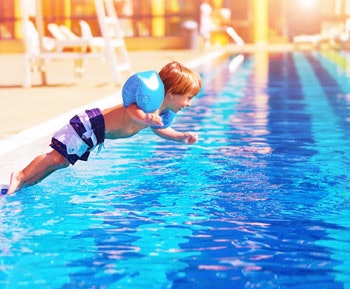 photo of a child jumping in a swimming pool