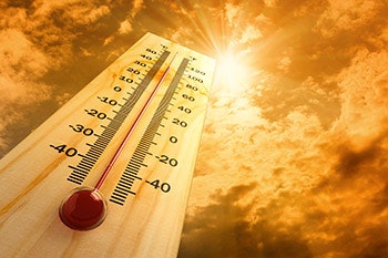 photo of a thermometer under a sunny sky
