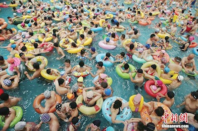 photo of people crowded in swimming pool tubes