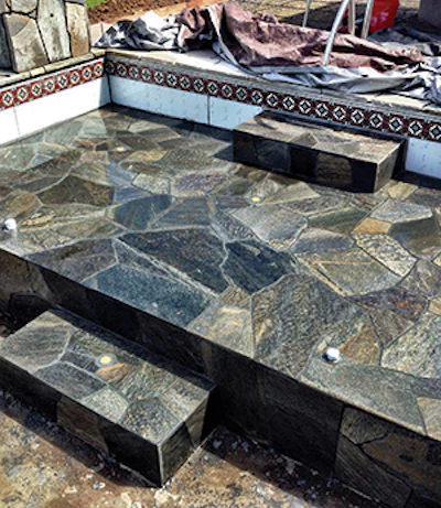 Vibrant colors and irregular shapes of the flagstone are enhanced by the color and texture of the grout material. Click to enlarge.