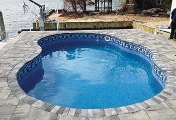 photo of an aboveground pool in a sloped backyard