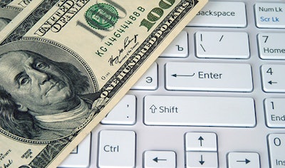 photo of a hundred dollar bill placed on a computer keyboard