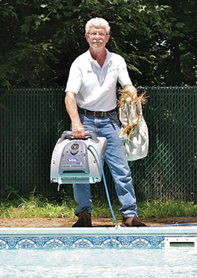 photo of a service tech using an automatic pool cleaner