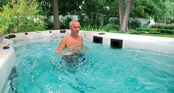 photo of a man using a Master Spas swim spa