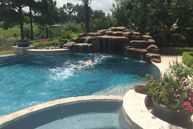 In this pool from Paragon Pools, water flows out of the grotto for both play and exercise. The current system is flush-mounted at the inlet and outlet with underground plumbing leading back to the pump.