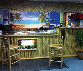 Palm tree imagery, bamboo-like textures and a thatched 'roof' come together to give this front counter a fun tropical vibe. - Click to enlarge