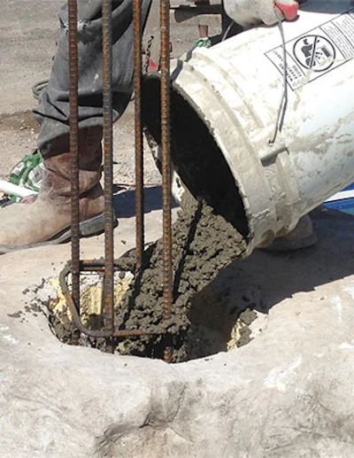 Fill columns with 3,000-psi concrete mix. Foam can be used as a filler around the columns.