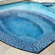 While portable spas are tough to beat when it comes to hydrotherapy and ergonomics, concrete spas can be designed and built to any shape and size, like this highly unusual spa that includes a trough lounger.