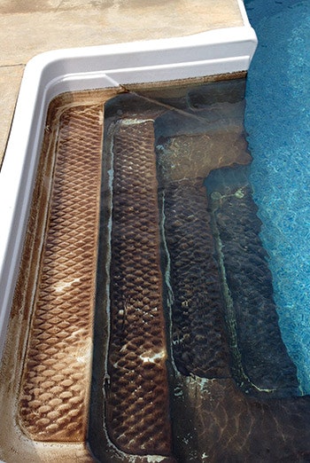 Iron in pool water can precipitate out easily, causing a brown stain like this one. Note how the deposited iron thickens with increasing depth on these pool steps.