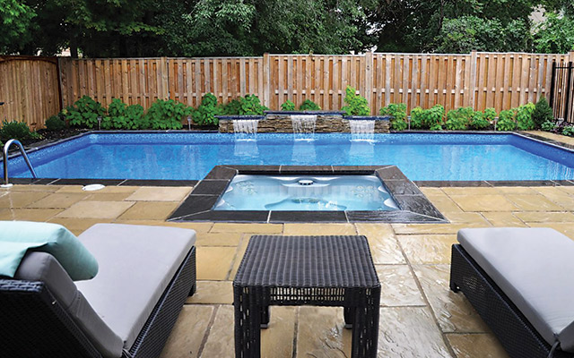 This vinyl-liner pool from Backyard Getaways was upgraded immensely by a drop-in spa with simple but gorgeous black stone coping.