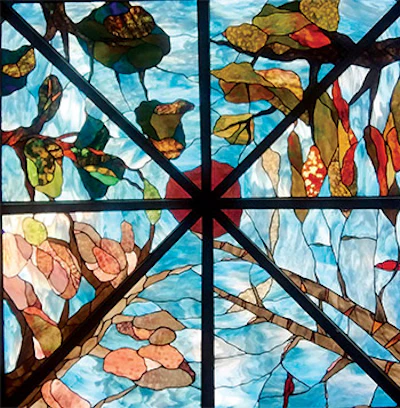 The stained glass in the roof depicts the four seasons and the panels on the sides depict local birds and the homeowner's two dogs.