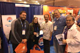 Ray Arouesty (center), John Oldfield (right of center) and guests at the IPSSA booth at the 2017 Pool & Spa Show.