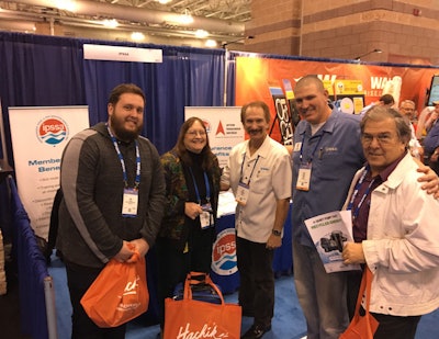 Ray Arouesty (center), John Oldfield (right of center) and guests at the IPSSA booth at the 2017 Pool & Spa Show.