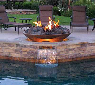 This metal fire bowl and spillway create an interesting destination above the water's edge that also functions as a decorative design element along the pool's raised bond beam. (Photo courtesy of Grand Effects)