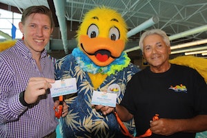 (L to R) YMCA Branch Executive Ray Fraser, Float Like A Duck Mascot Duckie and Float Like a Duck co-founder Joseph M. Vassallo display Pool Safely Water Watcher lanyards