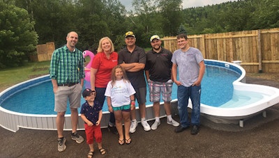 Leah's family pose with pool builders Cory Eagles and Brad Cross
