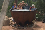 The hot tub is indeed anchored to a concrete foundation, but the wooden beams and chains help turn this hot tub into a backyard focal point.