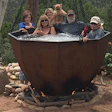 The hot tub is indeed anchored to a concrete foundation, but the wooden beams and chains help turn this hot tub into a backyard focal point.