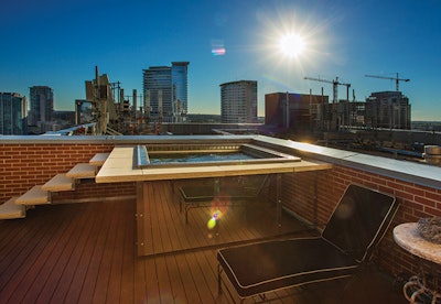 Today's spa designs are both luxe and sophisticated. This installation by Pool Environments (Plano, Texas) features the creative use of mirrored glass to hide the hot tub equipment and make this rooftop space look larger.