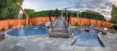 Another key feature, the bridge connecting the deck to the slide and rope swing area, includes sculpted planks inspired by Tolkien illustrations (above) and a classic arched design with custom rope rail and natural stone cladding (below), as well as fiber optic lighting and a rain feature (not pictured).