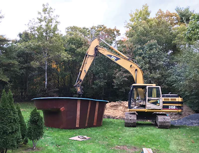 Aqua Med Pools' Cat 315 excavator carries the pool into the backyard. The same excavator that brings the pool digs the hole. (Photo courtesy Aqua Med Pools)