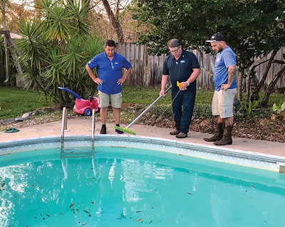 Gregg Minton (center) offers depth measurement instruction to workers from ASP.