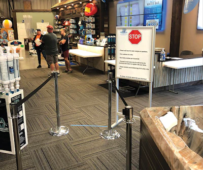 Some social distancing protocols — like this crowd control barrier — will remain in place when COVID strictures are lifted because retailers think they will be beneficial long term.
