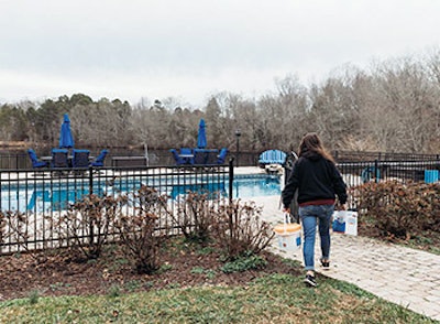 Felicia Finley visits one of the pools on her delivery route, chemicals in hand.