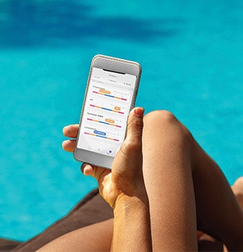 Blueriiot's water monitor sends pH, ORP, salinity and water temperature readings to the subscription-based Blueriiot app and an online dashboard monitored by service technicians. Here, a customer checks water conditions poolside. (Photo courtesy Blueriiot)