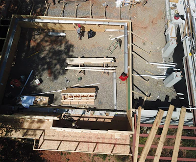 Aerial shot of an early stage of pool and spa construction. Workers are in the process of hanging the stainless steel drainage trough. Also evident is the forming for the concrete cantilever support structures. The house was close enough to Medallion Pools' office that they launched the photography drone from there to monitor progress and take pictures. (Photo courtesy Medallion Pools)