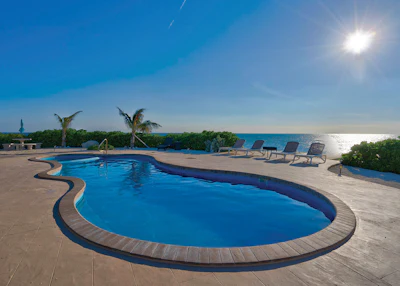 The pool itself is nothing elaborate, just a tidy fiberglass with attached spa, clean, well-executed coping and concrete deck. The trick is doing it out in the ocean, shipping in all supplies and equipment.