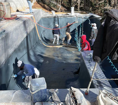 Finish work proceeds in the first exposed aggregate pool where EdenCrete was used in the mix.