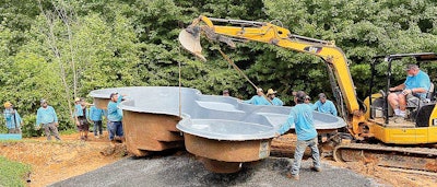 In this photo, a San Juan Desert Springs 14-by-30-foot pool/spa combo is making its way toward its final resting place, guided by the crew from Poolscapes of Charlotte.