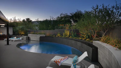 Subtle uplighting of the cacti and other plantings add lush mystique to the aquatic landscape painting, which now forms the backdrop of this home.