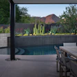 The design solution of a backyard renovation in Scottsdale, Ariz. was to frame the true subject of the backyard scene, obscure the competing roofline with an ironwood tree, and balance the tree with a vertical cacti element, forming an attractive composition.