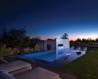 Pool and surroundings illuminated to beautiful effect. Note all the reflective surfaces and light sources, from the stars overhead to the floor of the pool.