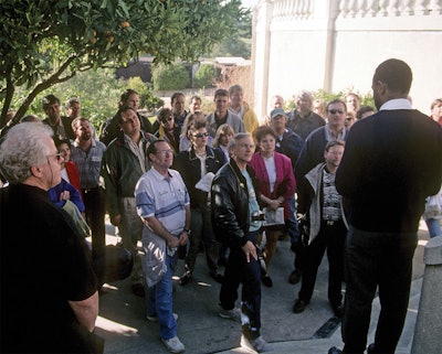 Una clase de Génesis se reúne en los escalones de la piscina del Castillo Hearst para dar una conferencia sobre una de las piscinas más emblemáticas jamás construidas. Algunas caras conocidas se encuentran entre la multitud.