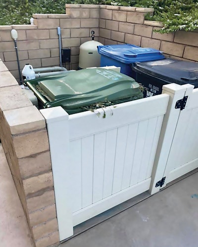 Paul Rodriguez has to share space with trash and recycling bins on this equipment pad, buried in the back of his customer's backyard and surrounded by brick walls.