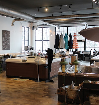 Los productos minoristas periféricos en Patio Pleasures (Sun Prairie, Wisconsin), como sombrillas y luces, ayudan a enfocar el sentido de la vista de los clientes, preparando el escenario para la relajación al aire libre.