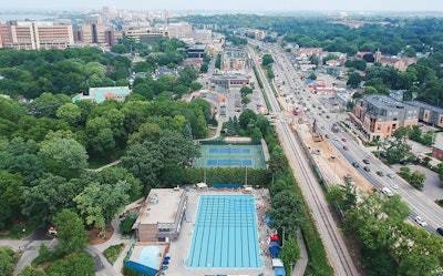 Toma aérea de la piscina, la etapa previa a la renovación y el campus circundante de la Universidad de Wisconsin, con el centro de Madison y el Capitolio a lo lejos.